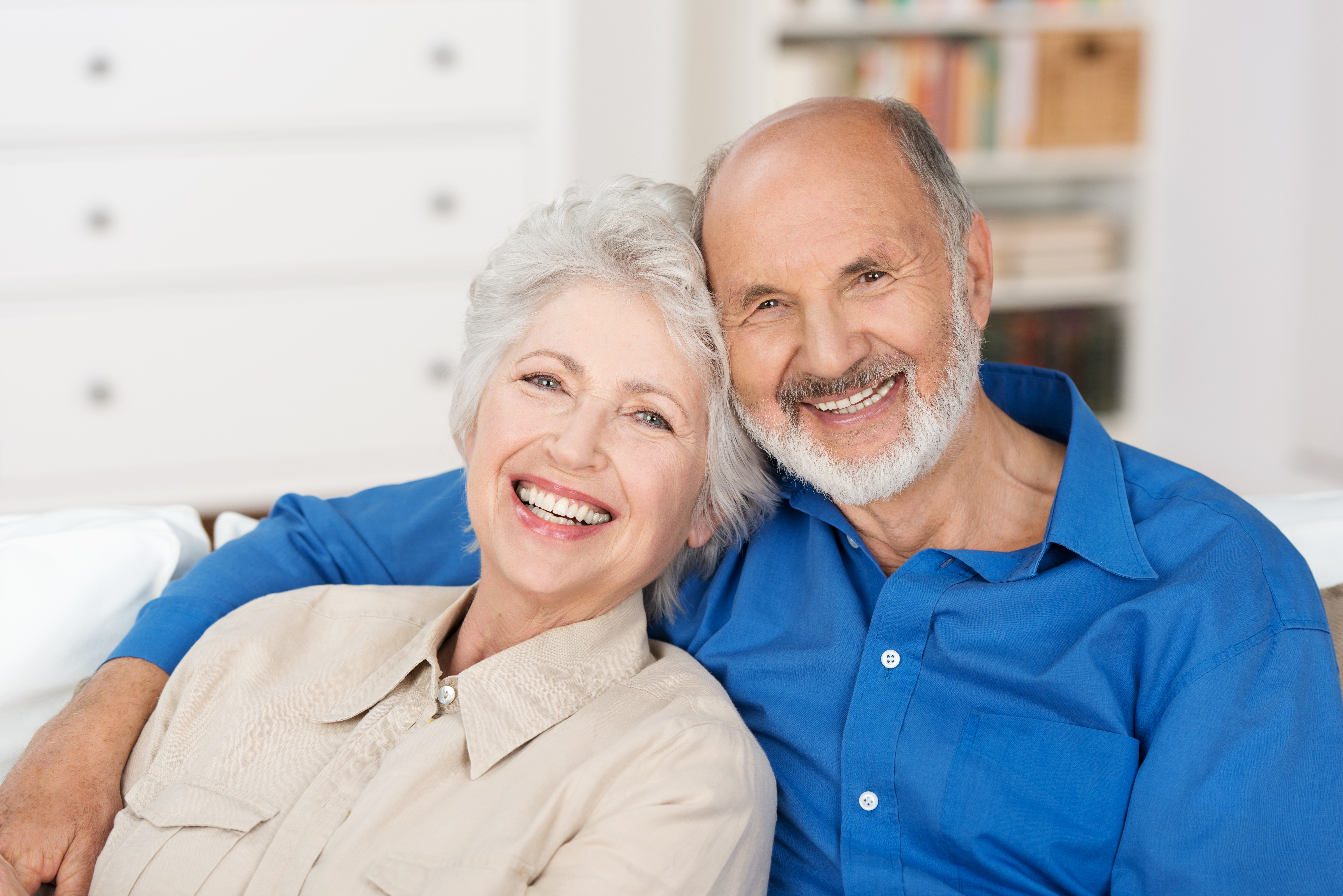 man smiling with his wife after getting dentures at Freedom Family Dentistry